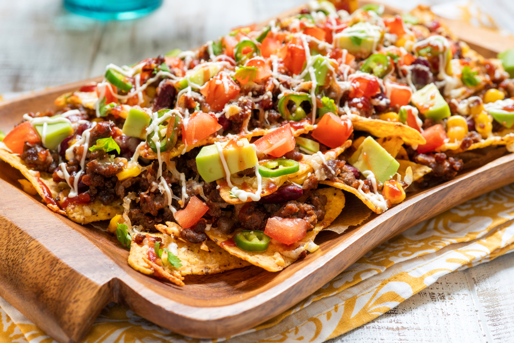 Nachos with homemade chili, avocado, tomato and cheese