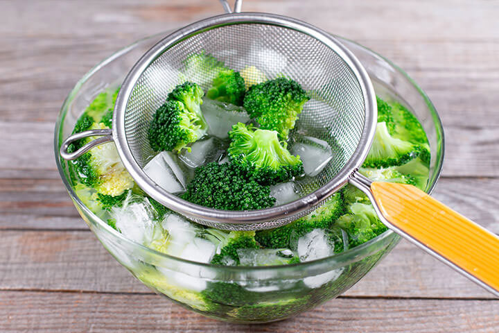 Petits bouquets de brocoli dans l’eau glacée pour stopper leur cuisson après les avoir blanchis dans l’eau bouillante