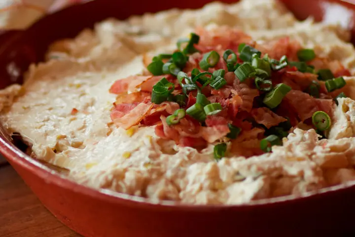 Hot cream cheese and leek dip with crunchy bacon topping