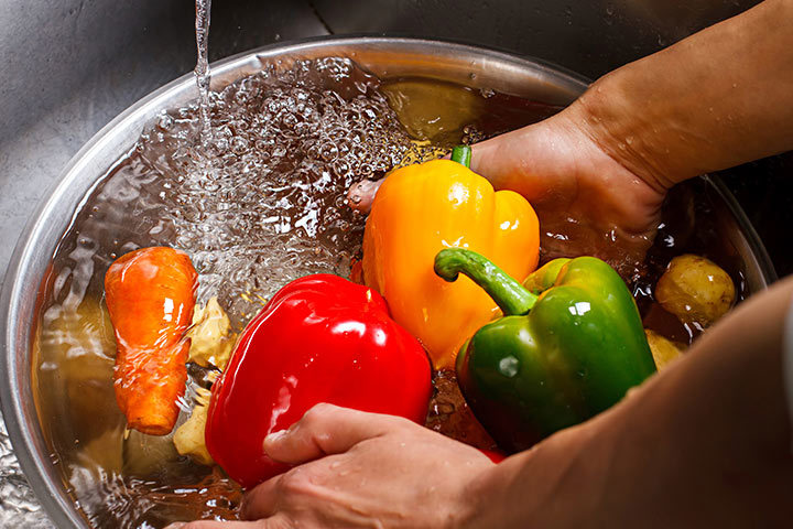 A person washes vegetables before cutting and freezing them