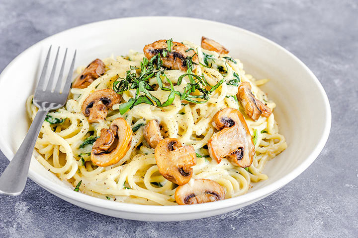 Recette de spaghettis avec une sauce à la crème et au vin blanc avec des champignons grillés en garniture