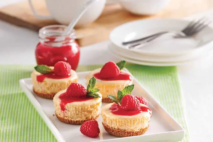 Mini cream cheesecakes with Graham cookie crust and raspberry coulis