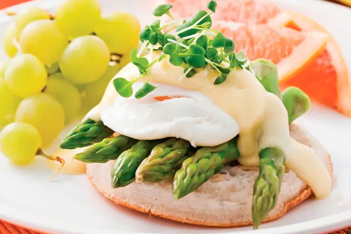 Traditional brunch recipe for eggs benedict with asparagus