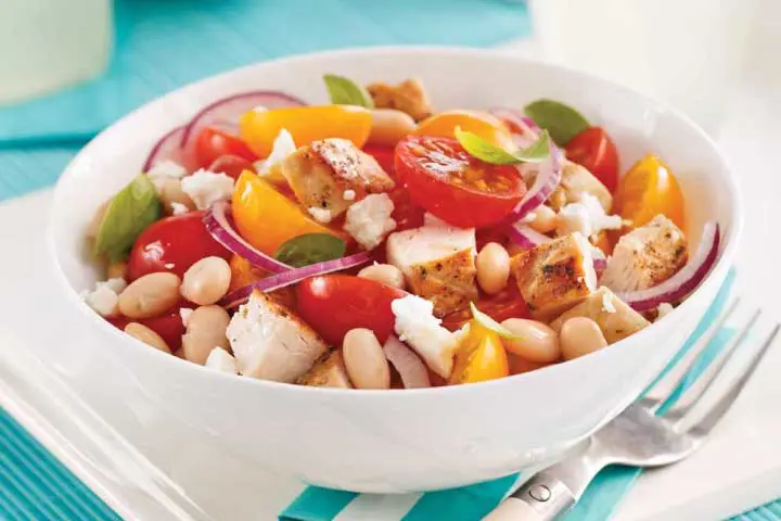 Salade méditerranéenne avec oignons rouges, poulet cuit, tomates cerises, haricots blancs et feta émietté